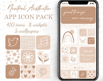 Può includere: Uno schermo di telefono che mostra un pacchetto di icone di app dall'estetica neutra con 410 icone, 8 widget e 5 sfondi. Le icone sono disposte in una griglia e presentano vari design, tra cui una farfalla, una nota musicale, un fiore e un cuore. Lo schermo del telefono mostra anche il testo "good things are coming" e "Happiness looks gorgeous on you".