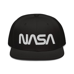 May include: A black and white NASA logo embroidered on a black flat brimmed baseball cap.