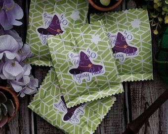 May include: Four green and white patterned gift bags with Harry Potter themed stickers. Each sticker features a purple witch's hat with a black lightning bolt and glasses, and the text "Harry Potter Mystery Pack".