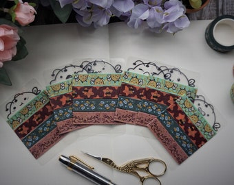 May include: A set of six clear plastic sheets with colorful patterned washi tape featuring a bee design. The tape is arranged in a semi-circle with the bee faces facing outward.