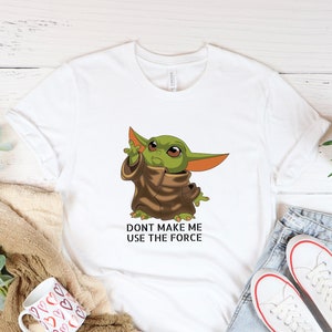Peut inclure: T-shirt blanc avec un personnage de dessin animé vert et le texte "Ne me force pas à utiliser la force".