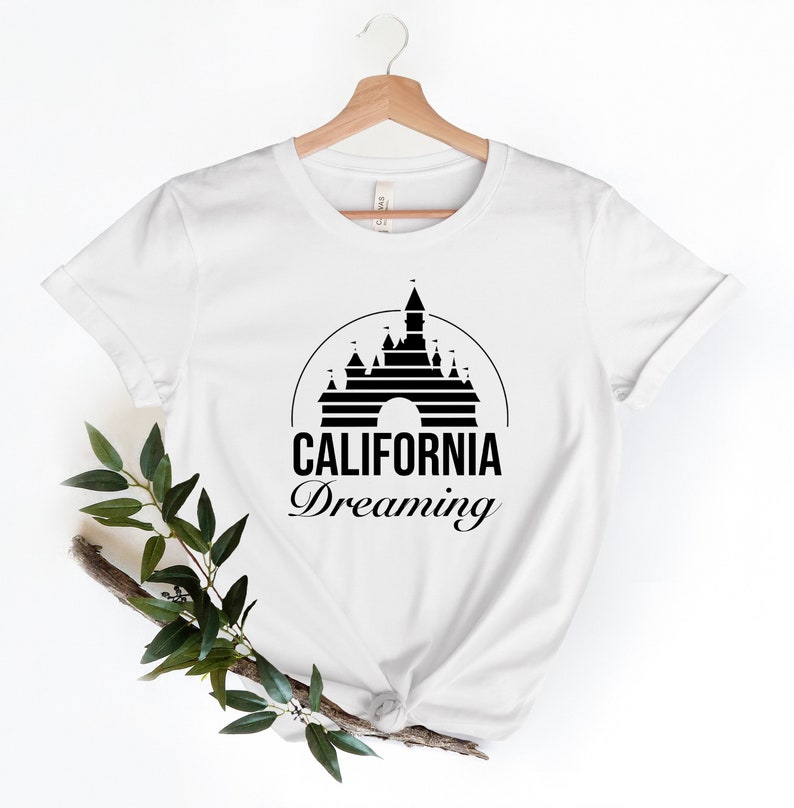 Puede incluir: Camiseta blanca con un gr&aacute;fico negro del castillo de la Bella Durmiente y el texto "CALIFORNIA Dreaming".