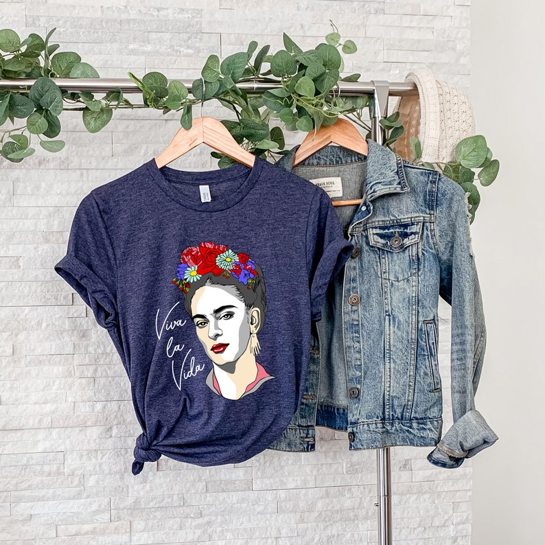 May include: A navy blue t-shirt with a graphic of Frida Kahlo wearing a flower crown and the text "Viva la Vida".