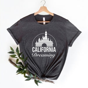 Puede incluir: Una camiseta gris oscuro con un gr&aacute;fico blanco del castillo de la Bella Durmiente y el texto "CALIFORNIA Dreaming".