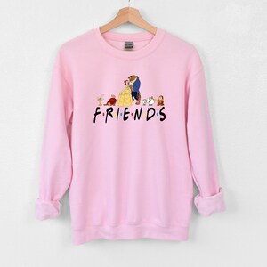 May include: Pink sweatshirt with a graphic of Belle and the Beast from Beauty and the Beast, along with other characters from the movie. The text "FRIENDS" is printed below the graphic.