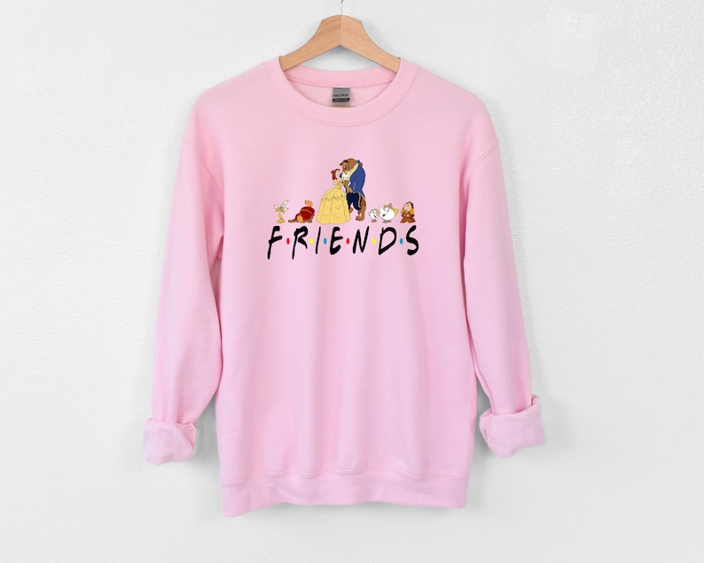 May include: Pink sweatshirt with a graphic of Belle and the Beast from Beauty and the Beast, along with other characters from the movie. The text "FRIENDS" is printed below the graphic.