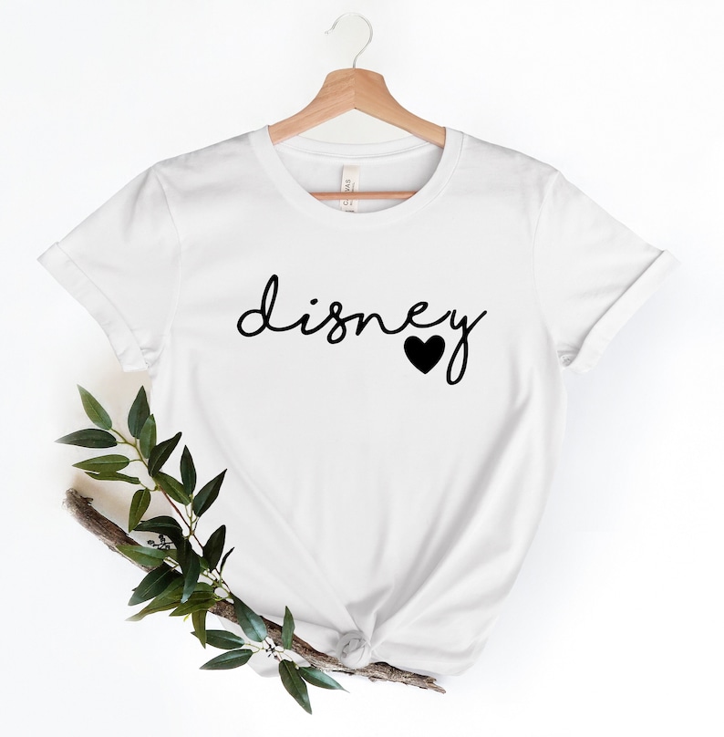 May include: White t-shirt with black text that says "disney" with a black heart after the word.