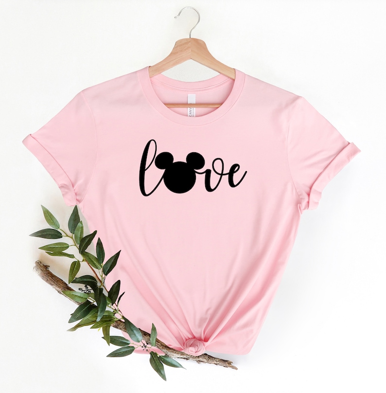 May include: Pink t-shirt with a black Mickey Mouse head and the word "love" in a cursive font.