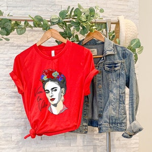 May include: Red t-shirt with a graphic of Frida Kahlo wearing a flower crown and the text "Viva la Vida".