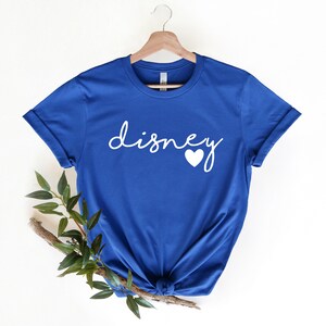 May include: A royal blue t-shirt with the word "Disney" in white cursive lettering and a white heart.