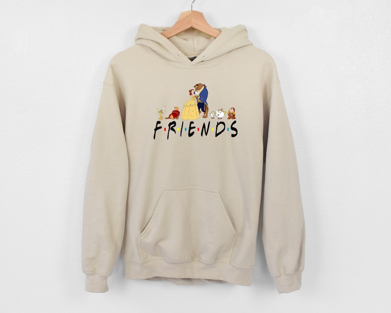 May include: Beige hoodie with a graphic of Belle and the Beast from Beauty and the Beast, along with other characters from the movie. The text "FRIENDS" is printed below the graphic.