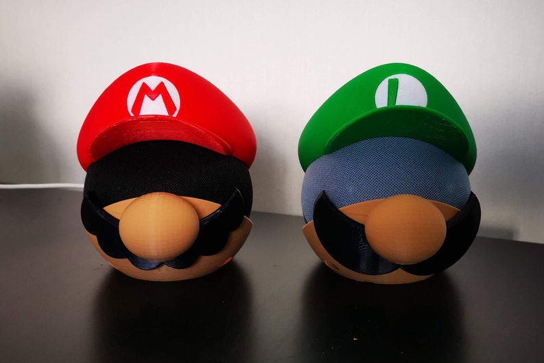 Mario and Luigi covers for Amazon Echo Dot. Mario is on the left using a black Echo Dot and Luigi is on the right using a white Echo Dot.