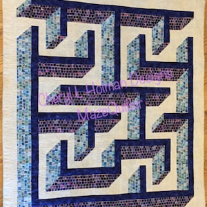 May include: A white fabric quilt with a blue and purple mosaic pattern. The pattern is a 3D optical illusion of a maze. The quilt is signed "Cheryl L Holman Designs Maze Quilter".