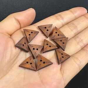 Puede incluir: Botones triangulares de madera marrón con diseños de hojas grabadas y tres agujeros. Adecuados para proyectos de costura y manualidades. Cada botón mide aproximadamente 2 cm.