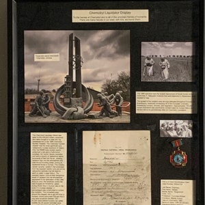 Exibição da medalha do liquidatário de Chernobyl para Sergey Zaginayo com cartão sindical da usina nuclear de Chernobyl