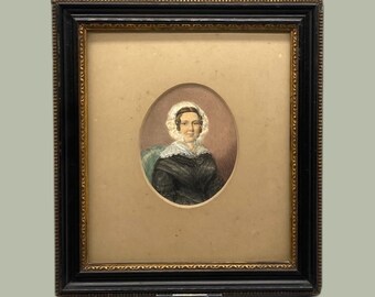 May include: A framed portrait of a woman wearing a white bonnet and a dark dress. The portrait is set against a light brown background.