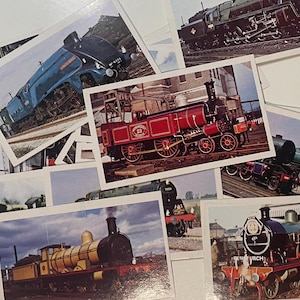 May include: A collection of vintage train cards featuring various locomotives. The cards showcase different train designs, including a blue and silver steam engine, a red and black steam engine, and a black and green steam engine. The cards are perfect for collectors of vintage train memorabilia.