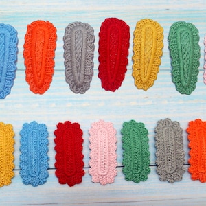 May include: Assortment of 14 crochet hair clips in various colors, including red, blue, green, yellow, gray, and pink. The clips are oval-shaped and have a delicate crocheted design.