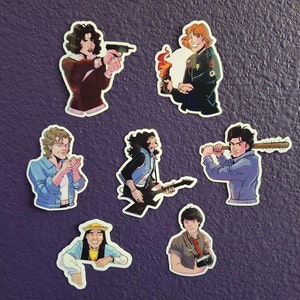 May include: Set of seven colorful stickers featuring various characters. The characters are drawn in a cartoon style and include a woman with a gun, a man with a guitar, a man with a baseball bat, a woman with a camera, a man with a cigarette, a woman with a molotov cocktail, and a man with a hat.