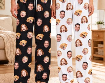 May include: Two pairs of pajama pants, one black and one white, featuring an all-over repeating pattern of printed faces of a man, a woman, a child, and a golden retriever dog. Both pairs have an elastic waistband with a white drawstring.
