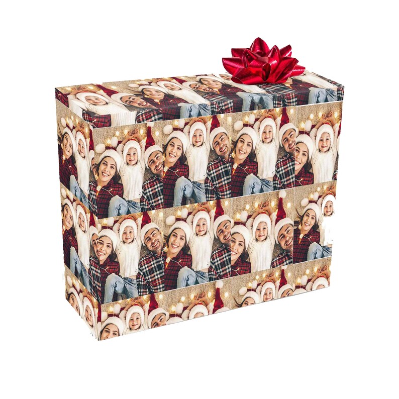 May include: A brown and beige gift wrap with a repeating pattern of a family wearing Santa hats. The family is smiling and looking at the camera. The gift wrap is decorated with small white lights.