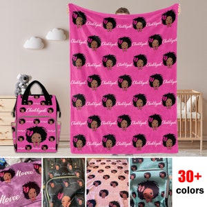 May include: Pink baby blanket with a repeating pattern of a black girl with a pink bow in her hair. The blanket is personalized with the name "Chakhyah". The image also shows a matching diaper bag with the same pattern and personalization.