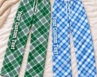 May include: Two pairs of lounge pants with an elastic waistband and white drawstring. One pair features a green and white plaid pattern, the other a blue and white plaid pattern. Both have the text Your Custom Text printed vertically.