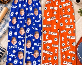 May include: Two pairs of lounge pants featuring a repeating pattern. The blue pair displays a photo of a boy, the name David, and the number 8. The orange pair features a repeating pattern of soccer balls, the name David, and the number 8.