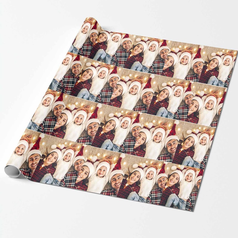 May include: A repeating pattern of a family wearing Santa hats and plaid shirts. The family is smiling and lying on a floor with string lights. The background is a light brown color.