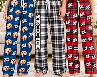 May include: Three pairs of pajama pants with drawstring waists. The left pair is blue plaid with golden retriever faces and the text YOUR LOGO. The center pair is black and white plaid with the text YOUR TEXT HERE. The right pair is red plaid with the text YOUR LOGO.