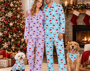 May include: Matching pajama sets featuring a repeating pattern of golden retriever faces wearing Santa hats and white snowflakes. One set is light purple, and the other is light blue. A small dog wears a matching light blue hoodie.