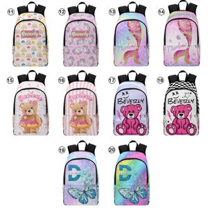 May include: Twenty different designs of personalized backpacks with various colorful patterns and images, including rainbows, unicorns, mermaids, teddy bears, butterflies, and glitter. Each backpack features a name, either "Beverly" or "Darlene", printed on the front.