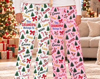 May include: Two pairs of lounge pants featuring a Christmas pattern with green pine trees, red bows, candy canes, and names including Emma, Liam, Oliver, Sophia, and Noah. The white pair reads This GRANDPA Belongs To and the pink pair reads This GRANDMA Belongs To.