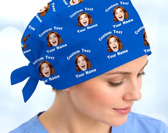 May include: A bright blue scrub cap featuring a repeating pattern of a person's face with auburn hair and an open-mouthed expression. The text Custom Text and Your Name is printed in white repeatedly across the fabric. The cap has a tie-back closure.