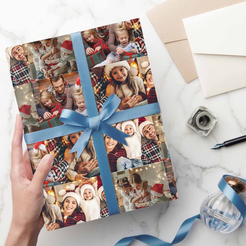 May include: A Christmas wrapping paper with a collage of family photos. The paper features a blue ribbon tied in a bow. The photos show a family celebrating Christmas with festive decorations.