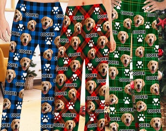 May include: Three pairs of pajama pants with a plaid pattern and a dog's face repeated throughout the fabric. The pants are in blue, red, and green plaid. The dog's name, "COOPER", is printed on the pants.