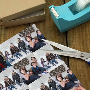 K&ouml;nnte beinhalten: Ein Blatt mit Fotos einer Familie in Winterkleidung, wobei eine Schere die Fotos in einzelne Quadrate schneidet. Die Fotos sind in einem Raster angeordnet, wobei jedes Quadrat ein anderes Familienmitglied oder eine andere Gruppe von Familienmitgliedern zeigt. Die Fotos sind auf wei&szlig;em Hintergrund gedruckt.