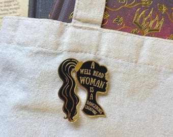 Uma mulher bem lida é uma criatura perigosa. Broche de esmalte preto rígido e literário.