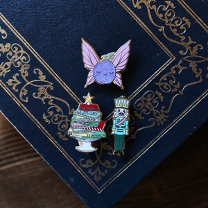Sugar Plum Fairy, Nutcracker, and Christmas Book Hard Enamel pins.