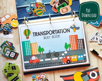 May include: A colorful transportation busy book with a hot air balloon, cars, a train, a bicycle, and buildings. The book is open to a page with the title "Transportation Busy Book".