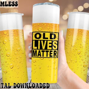 May include: A yellow and white tumbler with a black and white graphic that says "Old Lives Matter". The tumbler has a condensation effect.