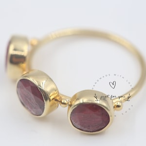 Può includere: Anello in oro con tre accenti di pietre preziose rosse. L'anello è inciso con "Handmade with love, just for you".