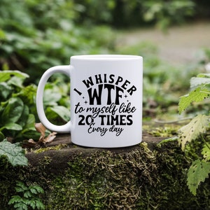 May include: A white ceramic mug featuring black text that reads I WHISPER WTF to myself like 20 TIMES Every day, with small star accents. The mug has a standard handle and a smooth, cylindrical body, presented as a functional beverage container.