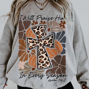May include: Gray sweatshirt with a leopard print cross design and the text "I Will Praise Him In Every Season Psalm 146:2"