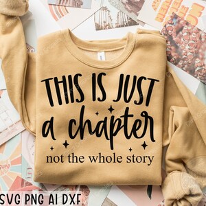 May include: A tan sweatshirt with the text "This is just a chapter not the whole story" in black lettering.