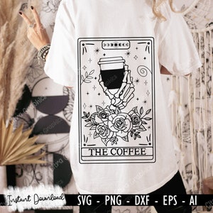 May include: Black and white illustration of a tarot card with a skeleton hand holding a coffee cup. The card is labelled "THE COFFEE" and is surrounded by roses and stars.