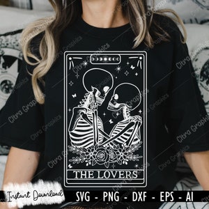 May include: A black and white tarot card illustration of The Lovers card. The card features two skeletons embracing with flowers at their feet. The card is framed with a black border and has the text "THE LOVERS" at the bottom.