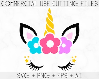 May include: A unicorn face silhouette with closed eyes, a gold horn, and a flower crown with pink, blue, and purple flowers. There are gold stars on either side of the face.