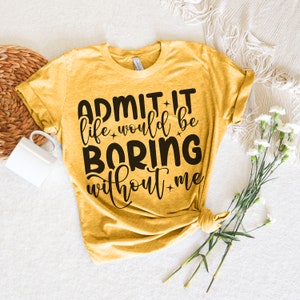 May include: A mustard yellow t-shirt with black text that reads "Admit it life would be boring without me".