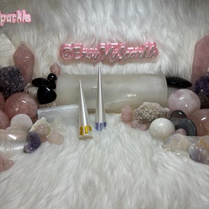 May include: Two white plastic cones with a yellow and blue number "30" printed on them. The cones are on a white fluffy surface with pink and white stones surrounding them. The text "@EveryMySparkle" is visible in the background.